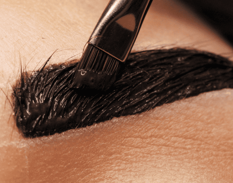 Close-up of a professional applying brow lamination and tinting to enhance eyebrow shape and color at Belle Ame Skin & Beauty.
